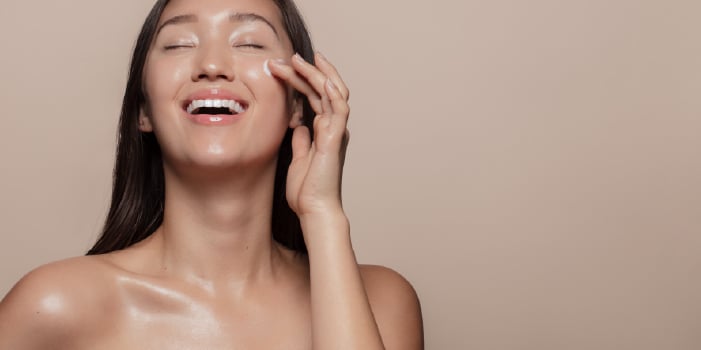 Woman uses CBD skin care to achieve healthy, glowing skin.