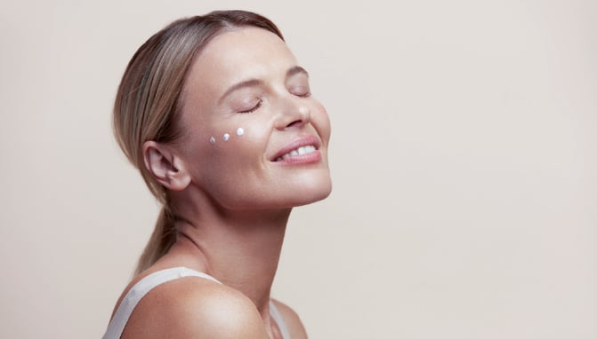 Woman using peptide skincare for healthy, youthful skin.