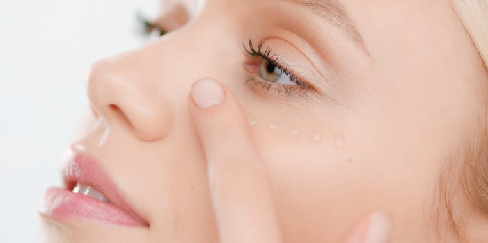 Woman applies serum to her face as part of spring skin care routine