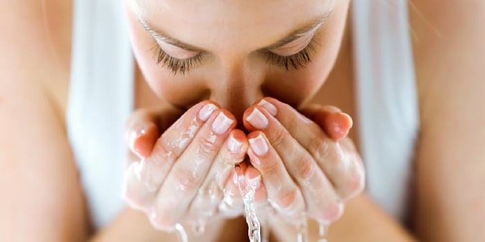 Woman washes her face as part of her spring skin care routine