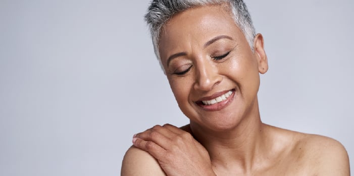 Middle aged woman who feels good in her skin because she uses skincare with peptides.