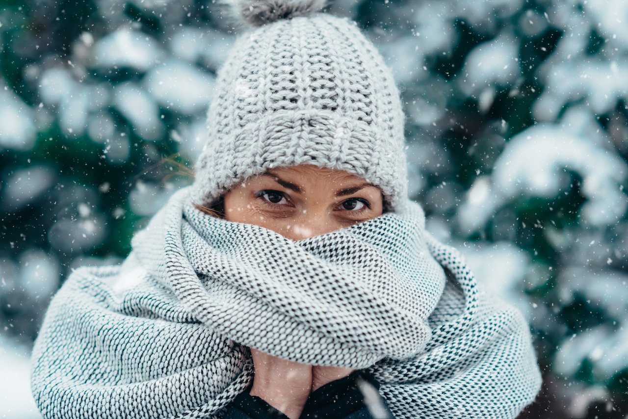 Young woman protecting her sensitive skin from extreme weather