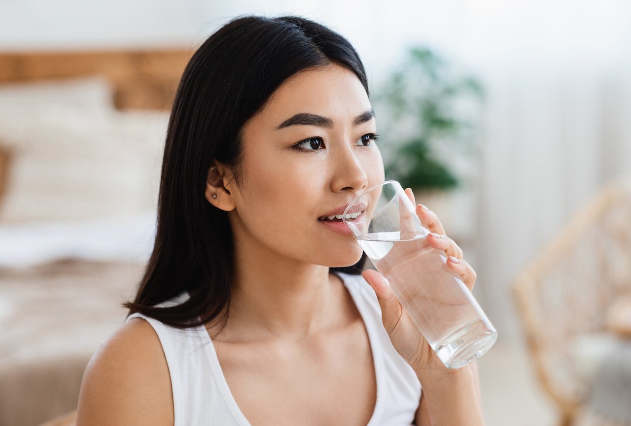 Young woman drinking water to stay hydrated