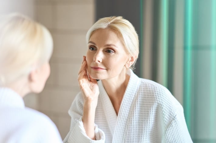 mature woman evaluating skin