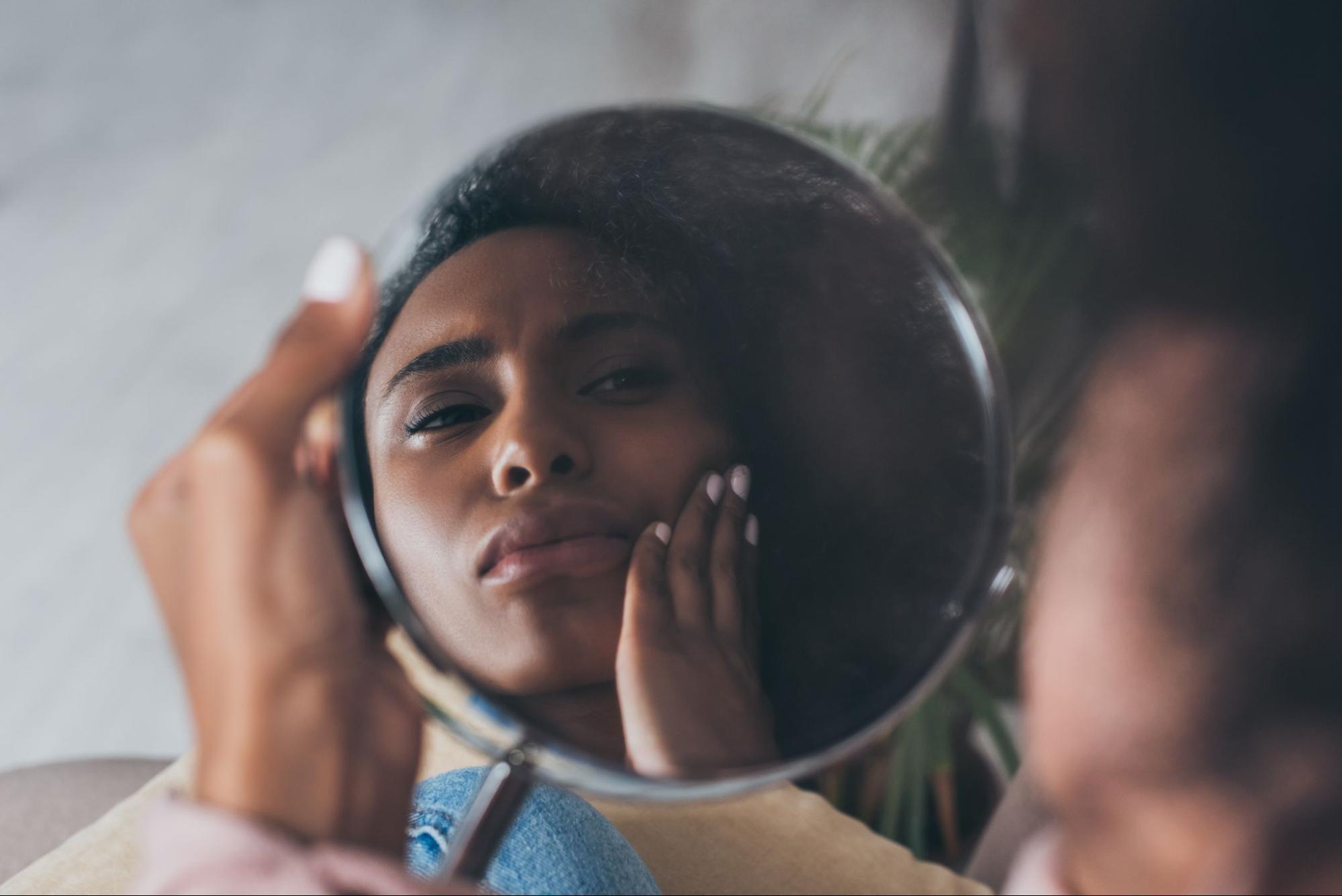 Woman rubs her face with a concerned look