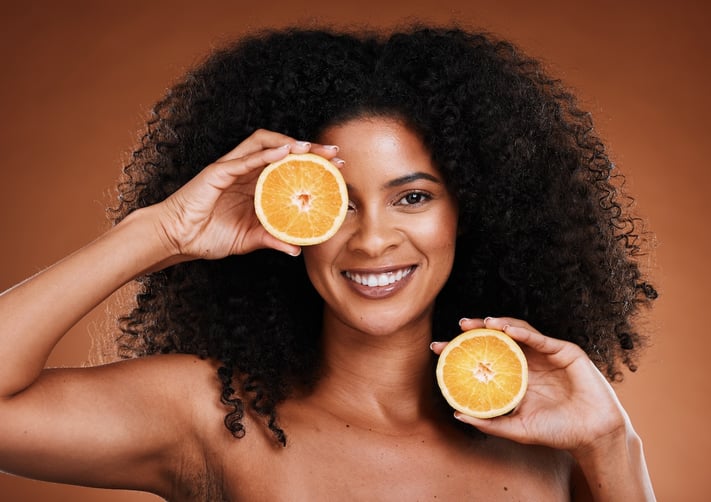 woman holding oranges that are a source of vitamin c