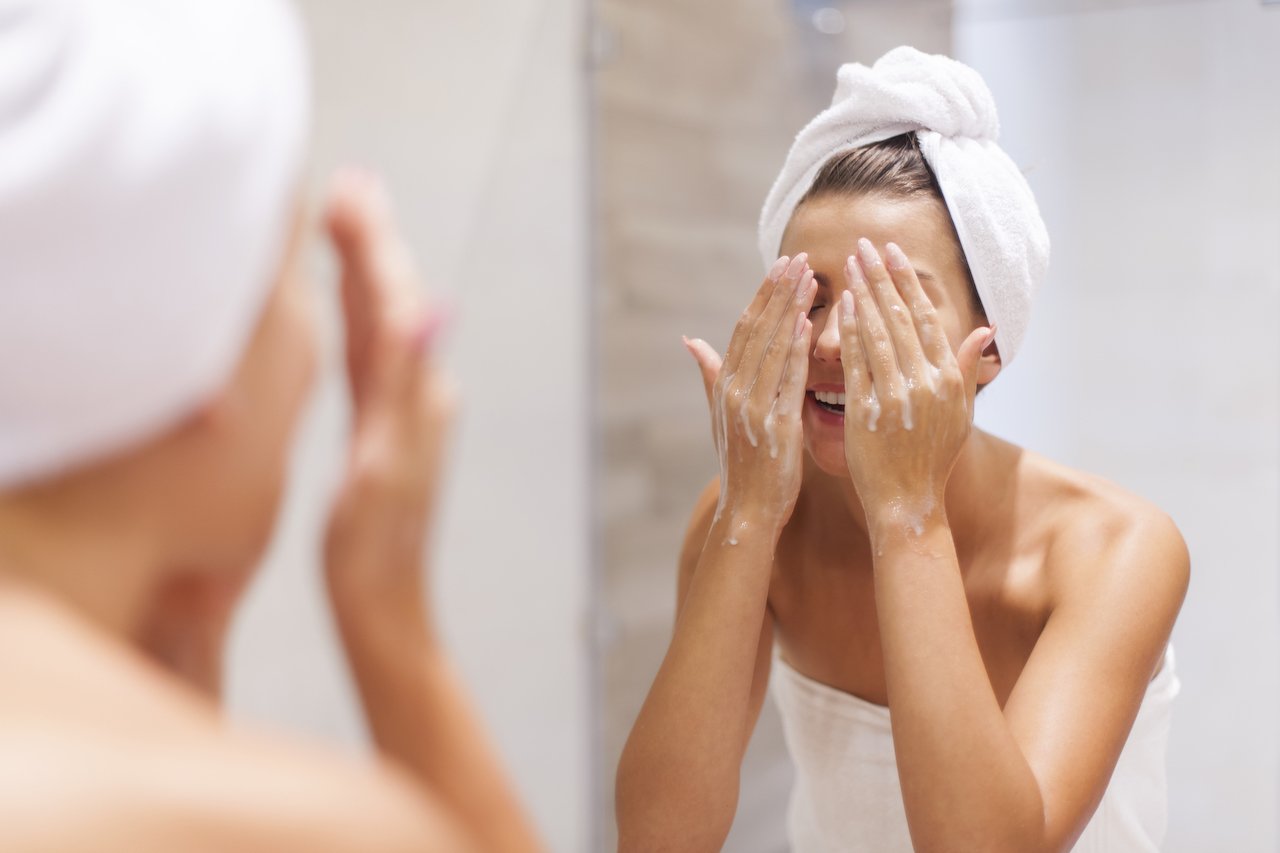girl washing her face using acne skincare products