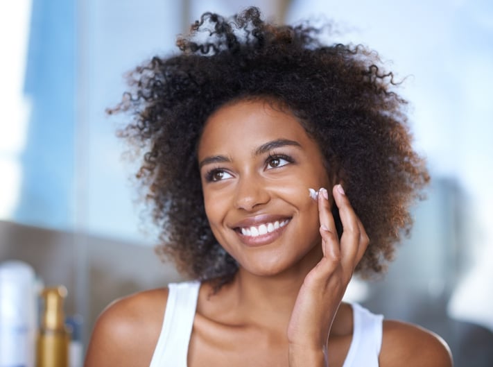 young woman applying hydrating skincare product