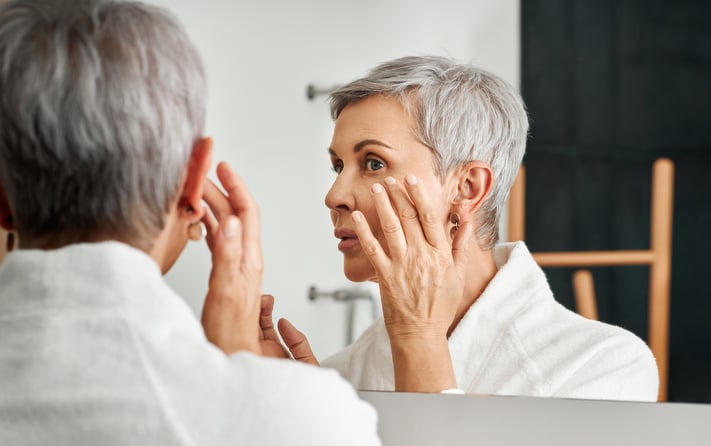 mature woman applying anti-aging skincare