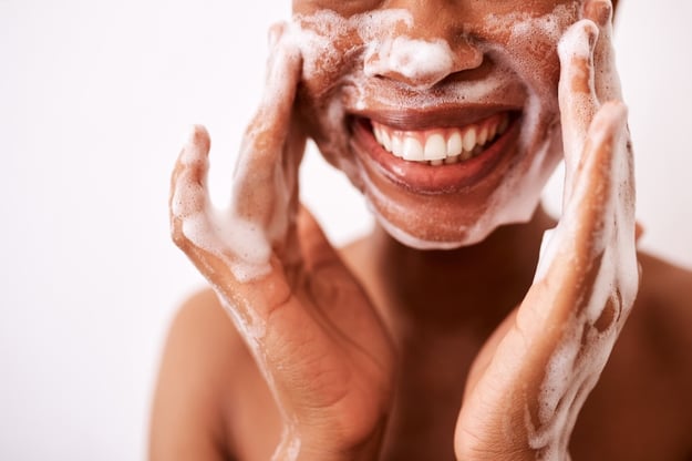 woman washing face as part of a skincare routine