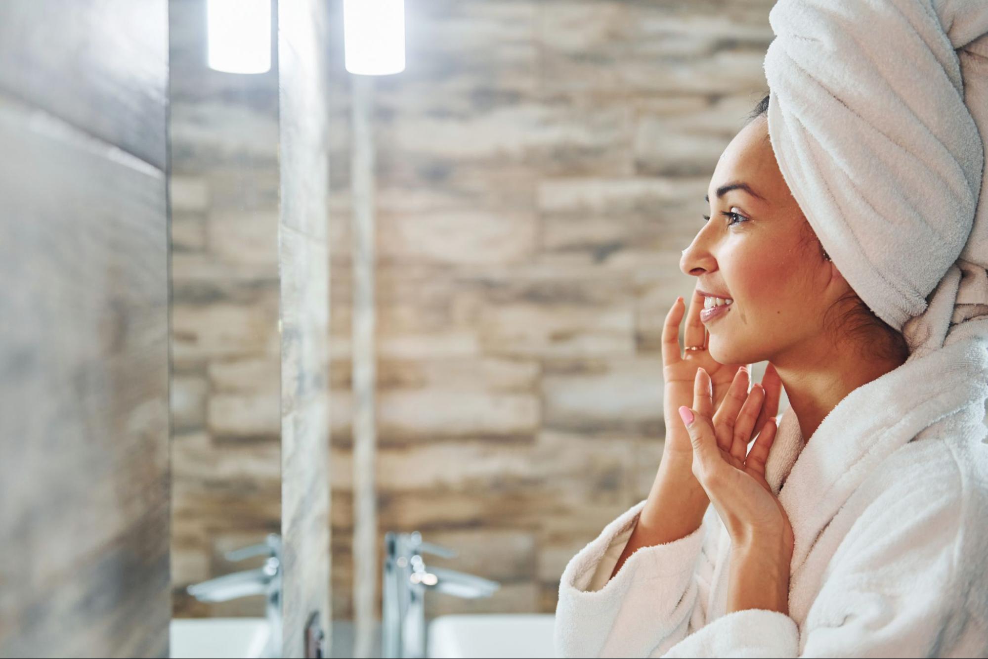 woman looking in mirror after washing her face