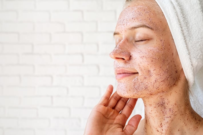 woman exfoliating to achieve smooth skin