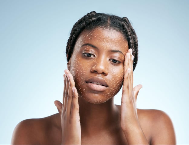 Woman rubs exfoliating scrub on her face