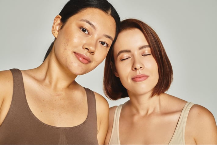 two women stand next to each other with soft smiles