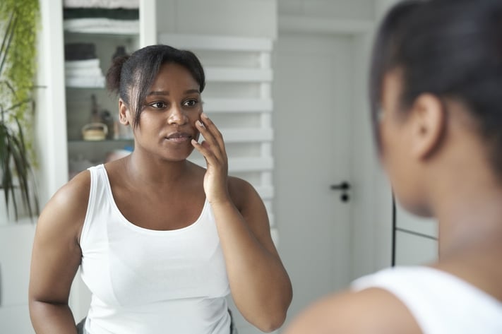 woman looking at damaged skin barrier