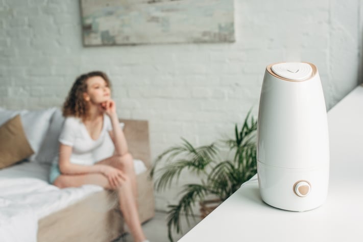 woman using humidifier to help combat dryness