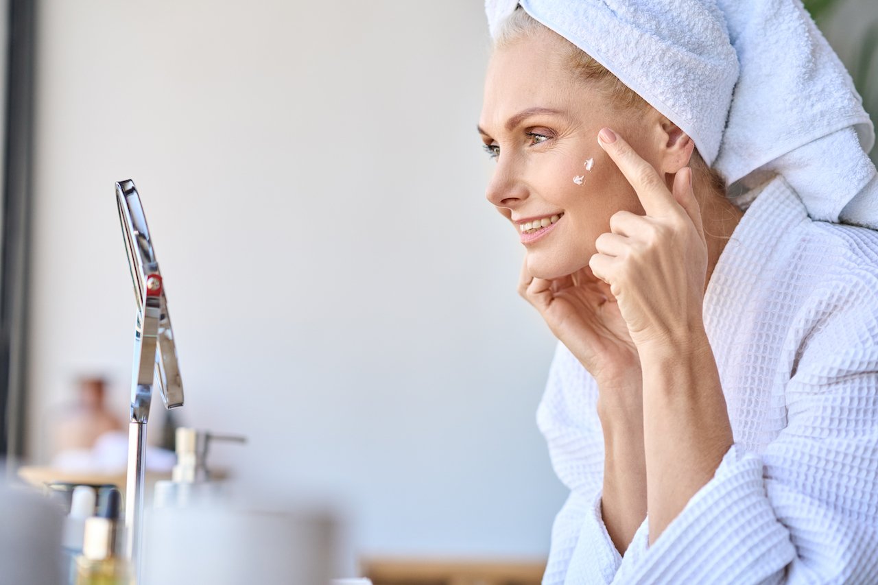 Middle-aged woman applying stem cell skincare products