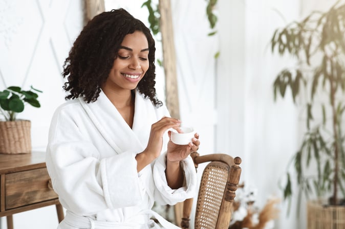 Woman applying products for dry skin after showering