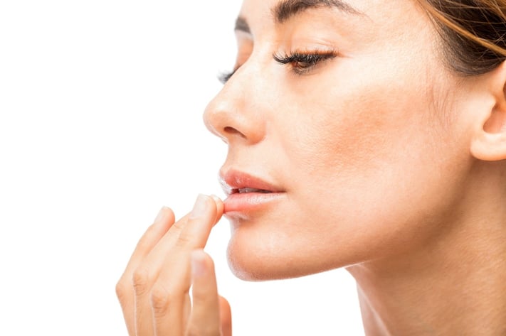 woman applying moisturizing lip balm