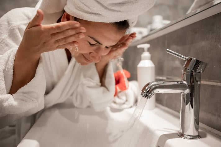 woman cleansing her face during bedtime routine