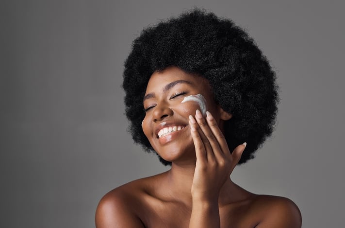 Woman moisturizing to avoid over-exfoliated skin