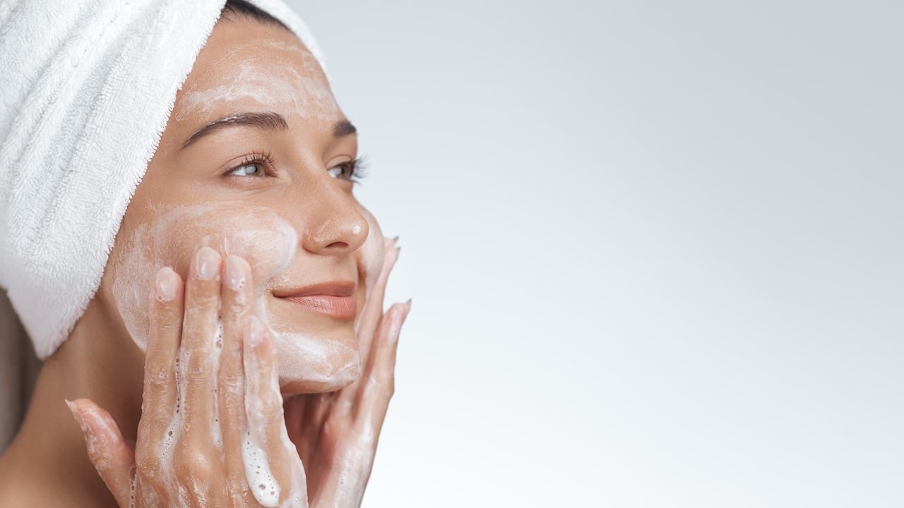 close up of woman washing face with active cleanser