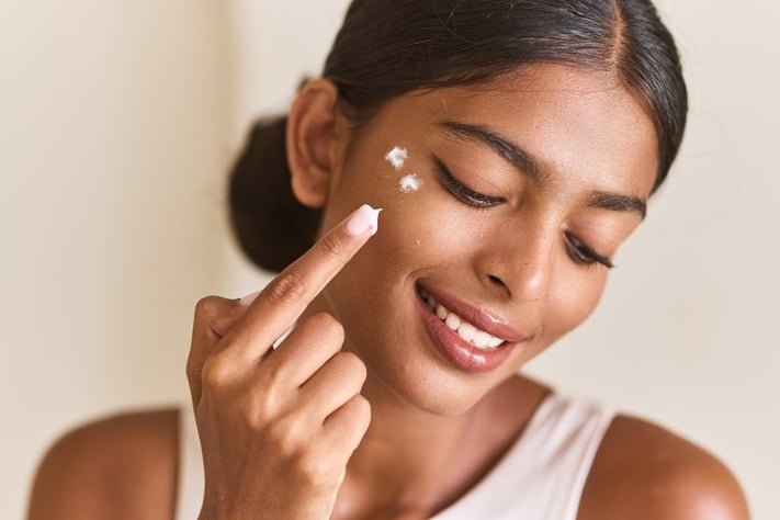 woman applying under eye cream