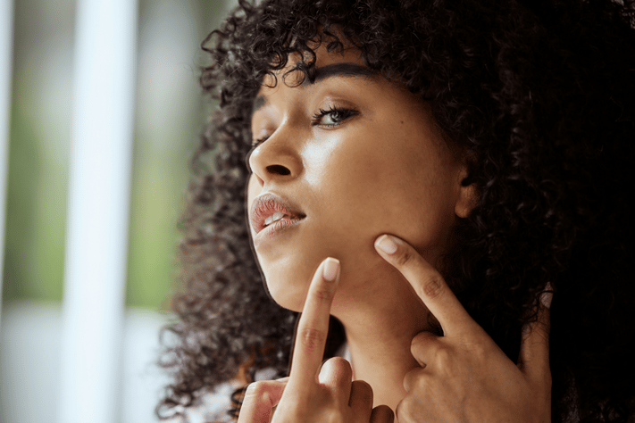 woman checking to see if skincare ingredients are working on oily skin