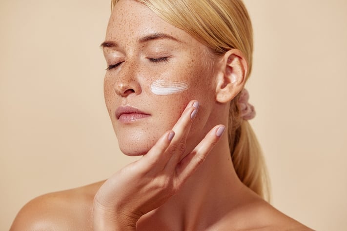 young woman applying sunscreen