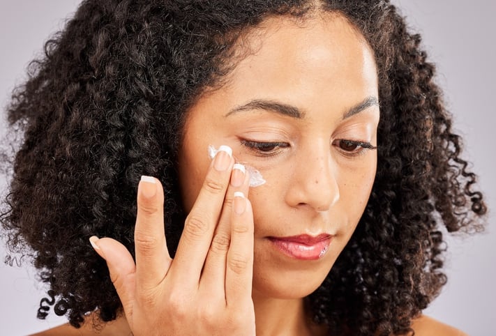 young woman applying moisturizer