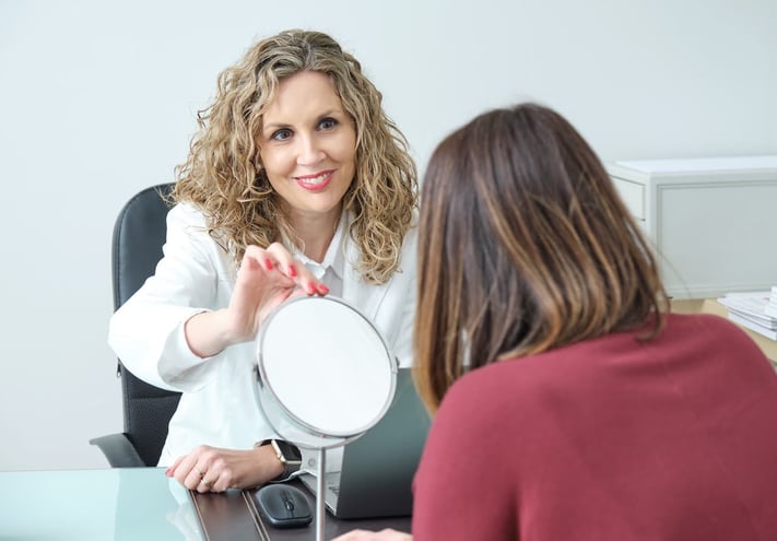 Skincare professional consulting with a woman