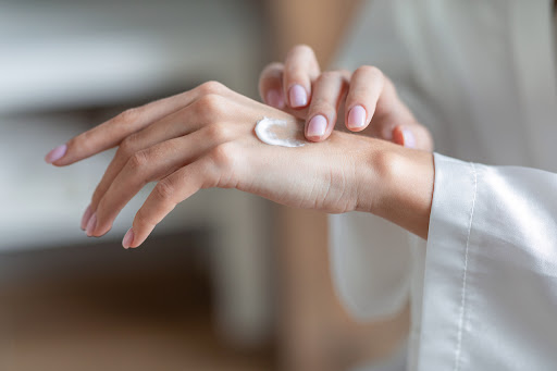 woman applying moisturizer to dry skin